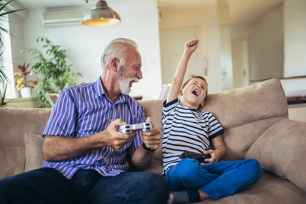 grandfather playing a video game with his grandson